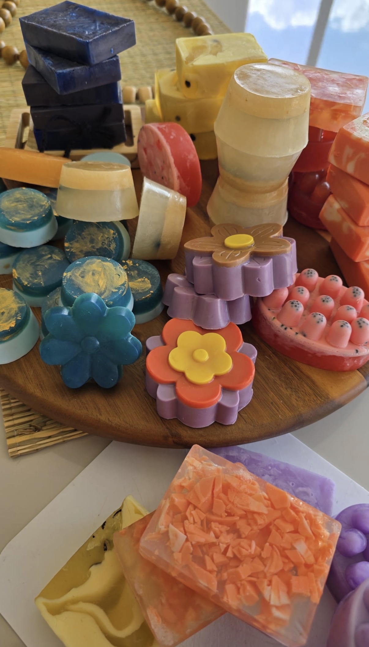 Closer view of the wooden display with blue, red and yellow bars, flower shapes and round soaps