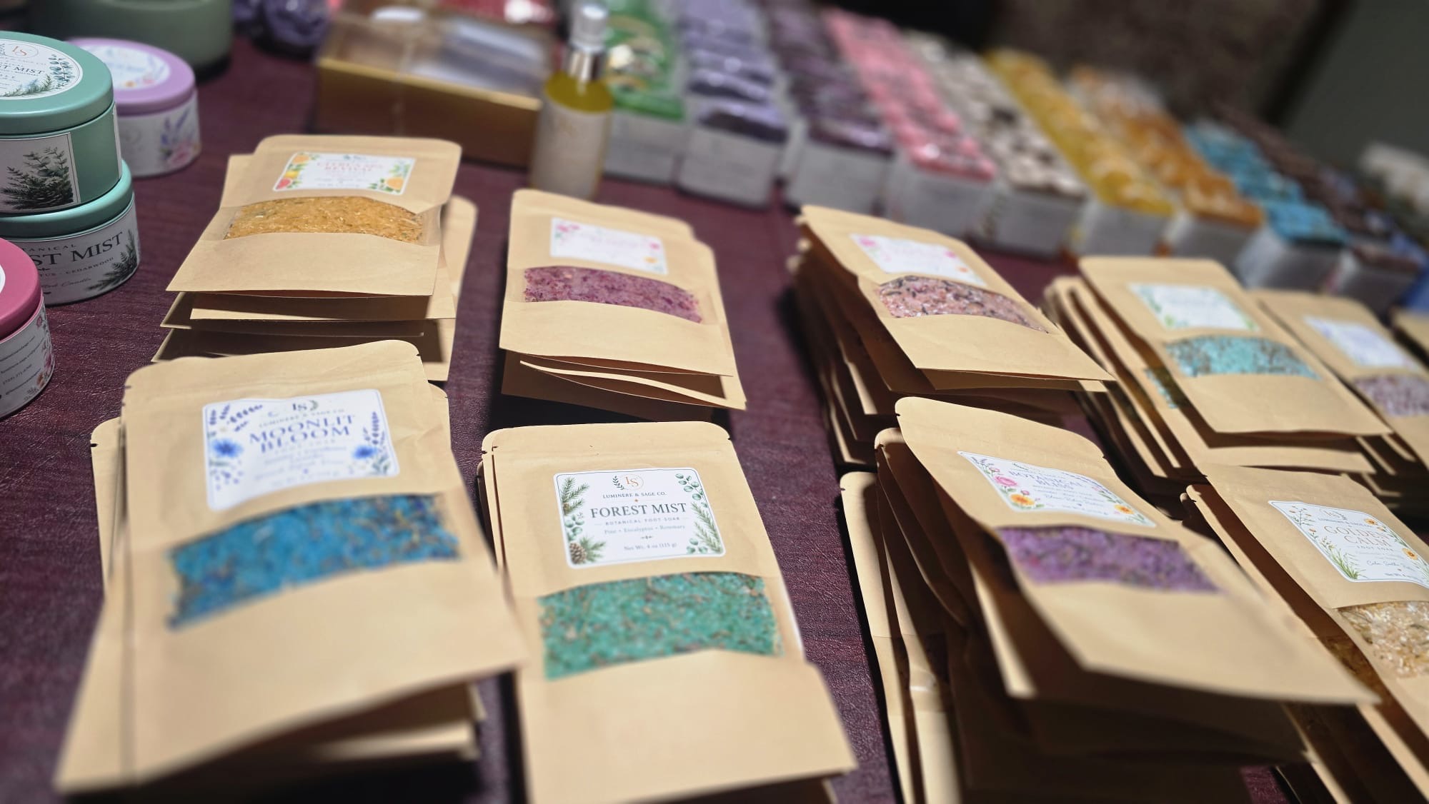 Kraft-pouch Luminere & Sage foot soaks arranged on a market table