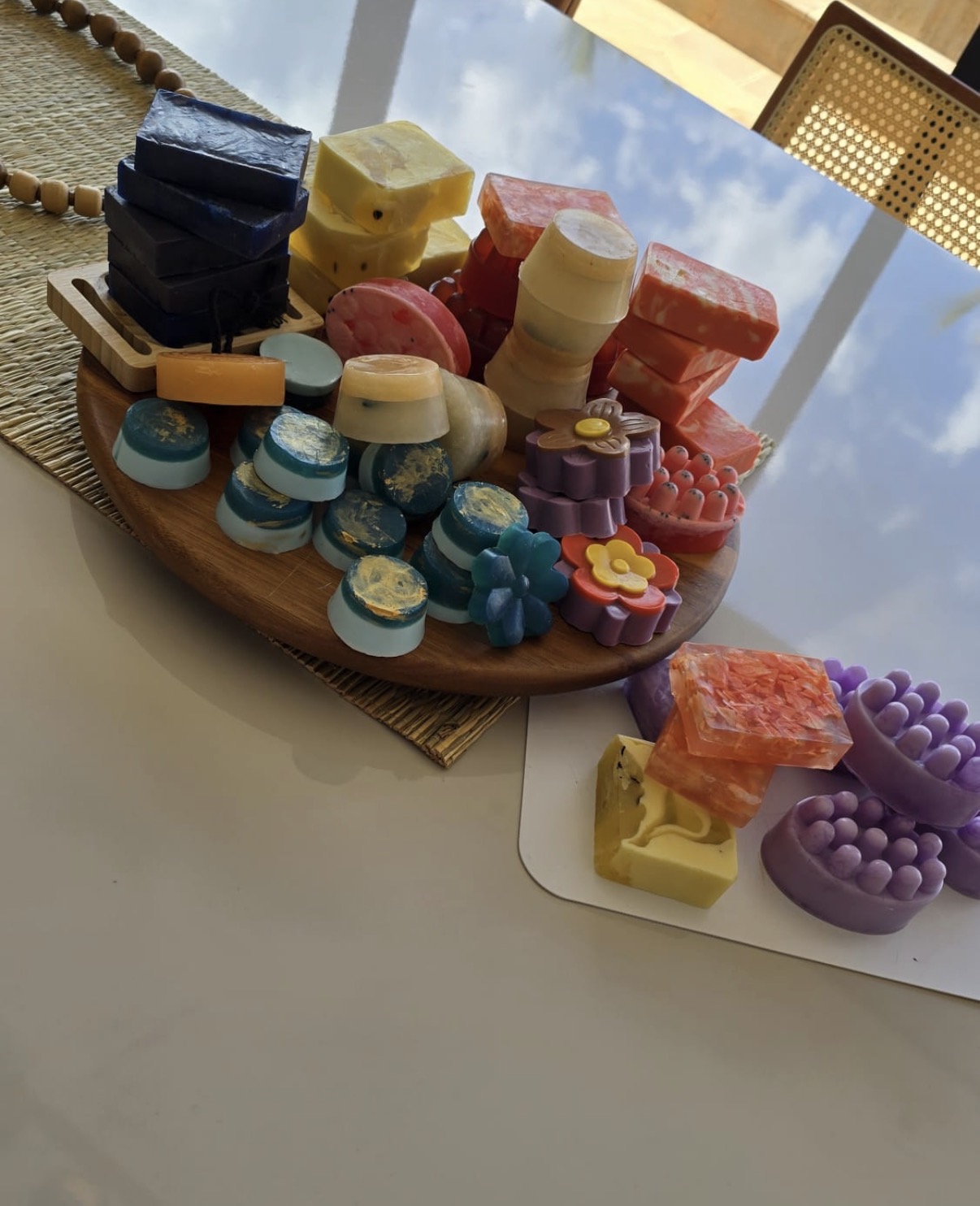 Colorful soap bars, round soaps, flower and massage-shaped soaps on a round wooden display