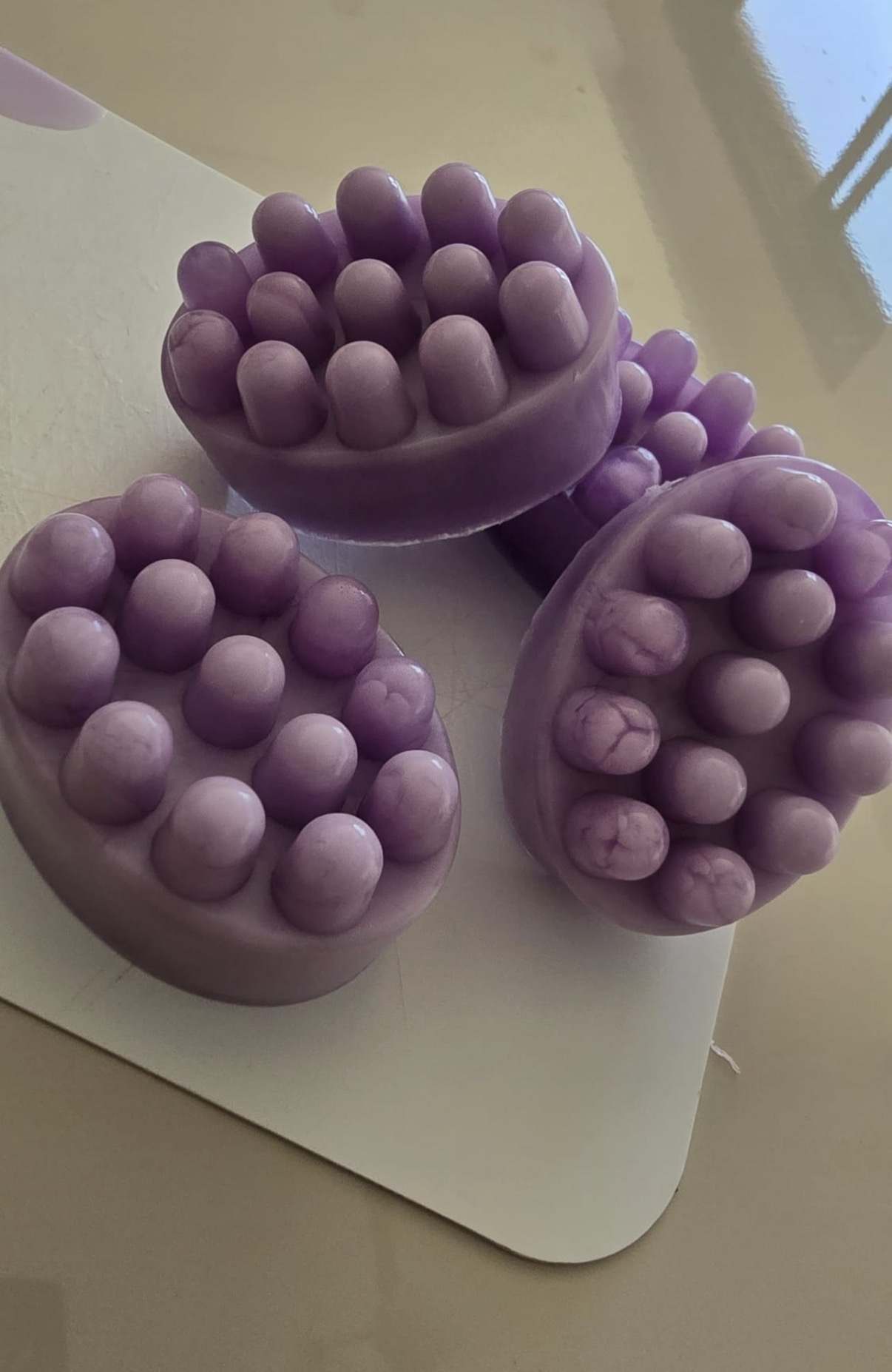 Purple massage-shaped facial soaps displayed together