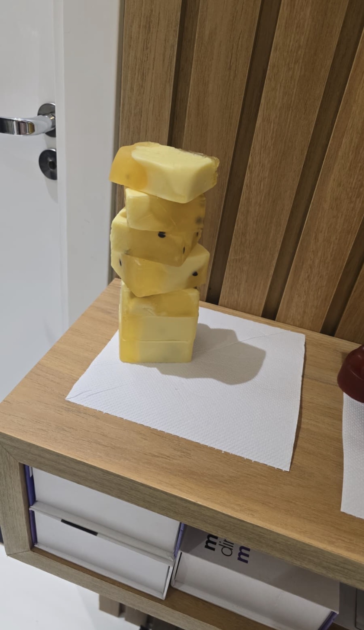 Stack of yellow rectangular soap bars on white paper and wood