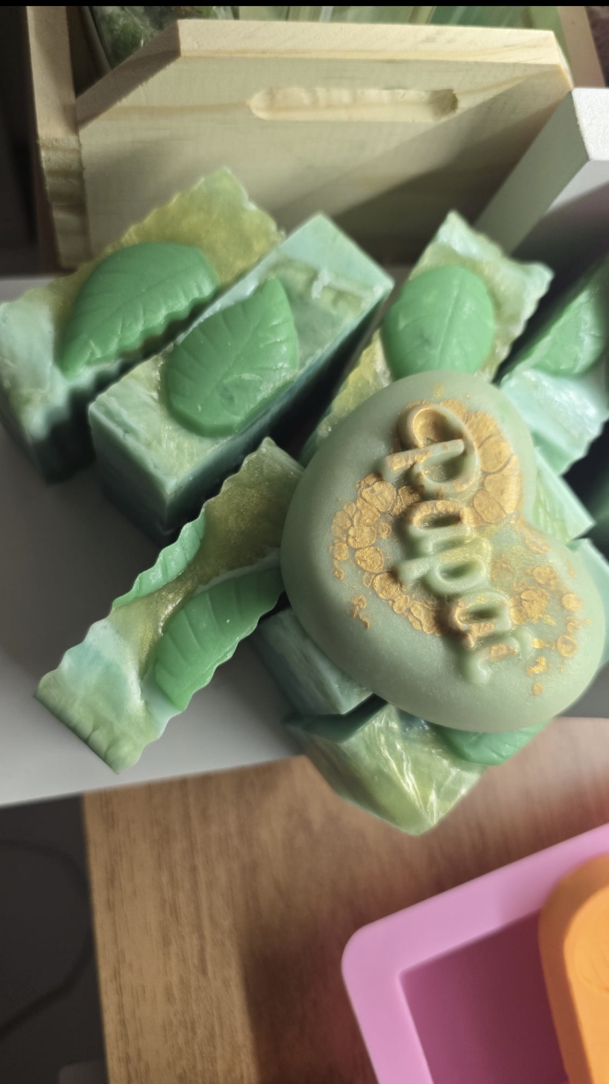 Green soap bars with leaf shapes and an oval soap reading Papai in gold